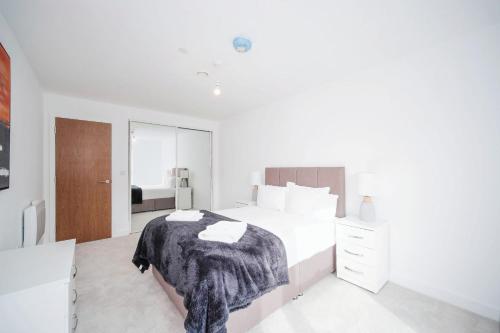 a white bedroom with a bed and a mirror at Modern 1Bed Apt with Parking - Grand Exchange Bracknell in Bracknell