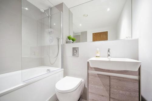 Baño blanco con aseo y lavamanos en Modern Luxury - Grand Exchange Bracknell, en Bracknell