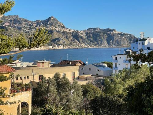 vistas a una ciudad con el océano y las montañas en John Sea Suites en Giardini Naxos