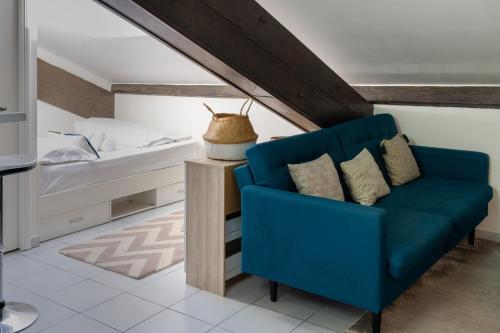 a bedroom with a blue couch and a bed at DIFY Dugas Montbel - Presqu ile in Lyon