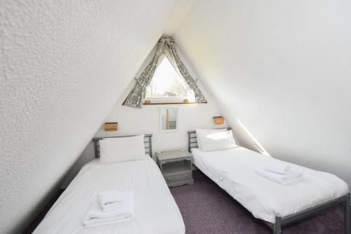 Tempat tidur dalam kamar di FRONTLINE Stylish Coastal Chalet 11 with Sea Views