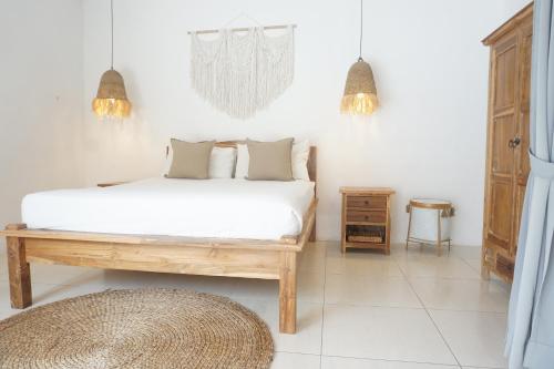 Dormitorio blanco con cama y mesa en Villa Pagu, en Seminyak