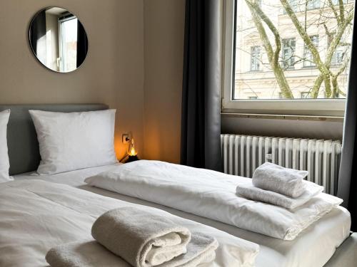 Un dormitorio con dos camas con toallas encima. en Hotel Sendlinger Tor, en Múnich