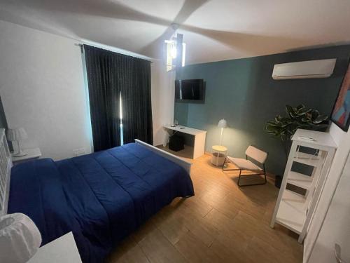 een slaapkamer met een blauw bed en een bureau bij Casa Matuta in Santa Maria Capua Vetere