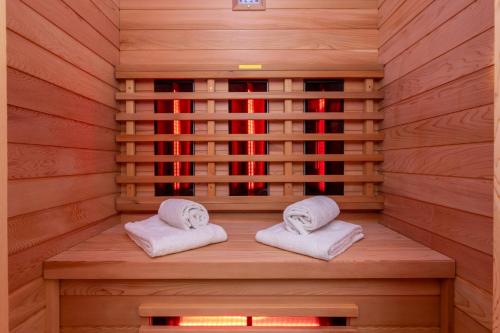 - un sauna avec 2 serviettes assises sur un banc en bois dans l'établissement Appartement - Nieuwstraat 1 - Zoutelande 'Kurhaus - 4 met sauna', à Zoutelande