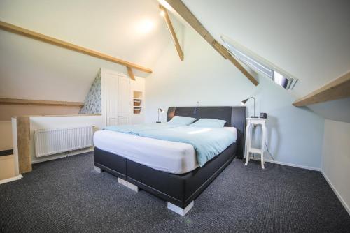 een slaapkamer met een groot bed op zolder bij B&B Louisehoeve in Linschoten