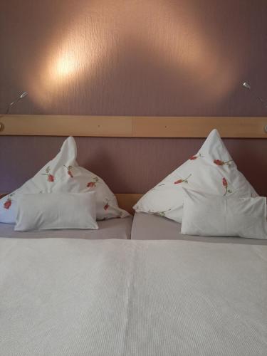 a bed with three pillows on top of it at Fewo Zum Sonnenschein in Simmerath