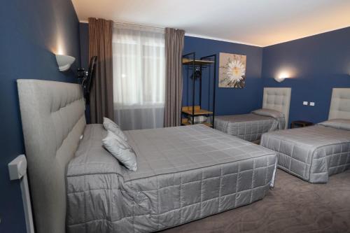 - une chambre avec 2 lits et des murs bleus dans l'établissement Auberge Le Semnoz, à Saint-Jorioz