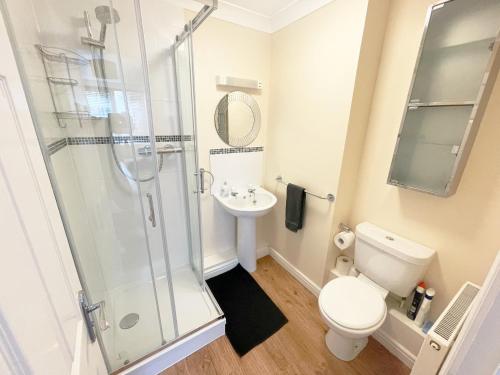 uma casa de banho com um chuveiro, um WC e um lavatório. em Travaal.©om - 2 Bedroom Apartment - Farnborough em Farnborough