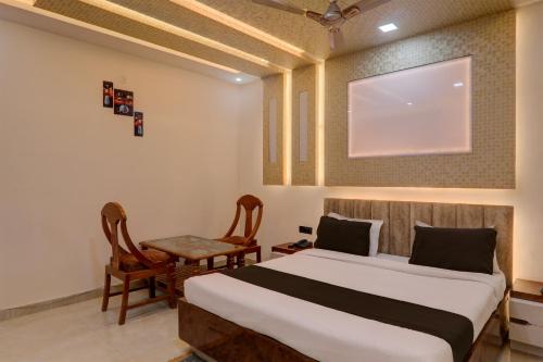 - une chambre avec un lit, une table et des chaises dans l'établissement OYO Flagship Hotel Blue Lake Inn, à Lucknow