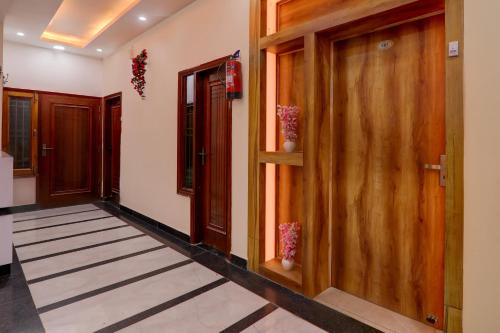 - un couloir avec des portes en bois et du carrelage dans l'établissement OYO Flagship Hotel Blue Lake Inn, à Lucknow