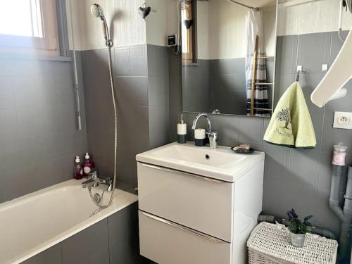 a bathroom with a sink and a bath tub at Appartement au pied des pistes in Les Fourgs