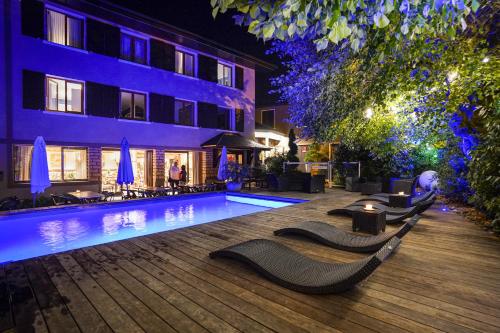 a swimming pool in front of a building at night at Auberge Le Semnoz in Saint-Jorioz