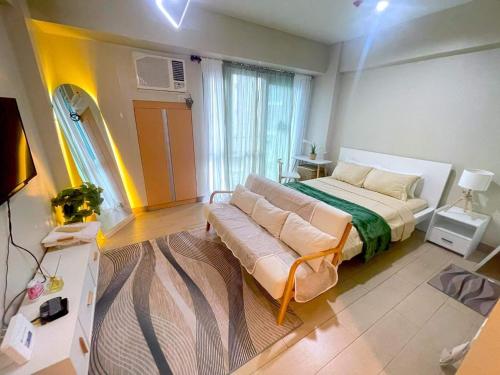 een slaapkamer met een bed en een bank erin bij Two Palm Tree Villas in Manilla