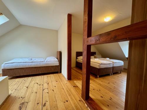 two beds in a room with wooden floors at Apartmány Laubeho náměstí in Teplice