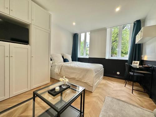 une chambre avec un lit, une télévision et une table dans l'établissement Le P’tit Anatole, à Moulins