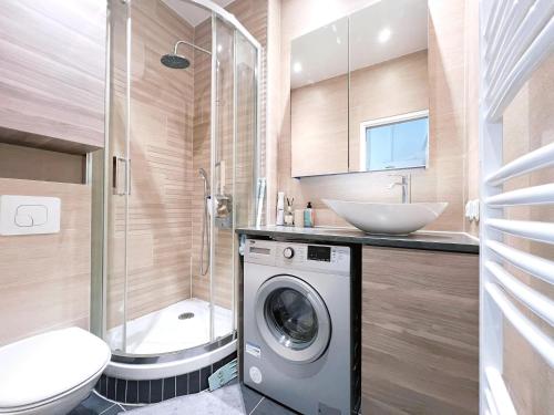 une salle de bain avec une machine à laver et un lavabo dans l'établissement Seine Apartment, à Paris