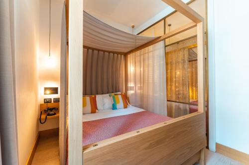 ein Schlafzimmer mit einem Himmelbett in einem Zimmer in der Unterkunft Albergo Caffe Centrale in Mezzocorona