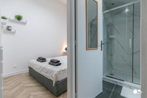 Schlafzimmer mit einem Bett und einer Glasdusche in der Unterkunft MBA Splendide Appart - Le Raincy RER Banlieue Paris in Le Raincy