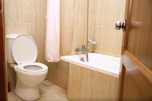 y baño con aseo, lavabo y bañera. en GLORY SUMMIT HOTEL HOIMA, en Hoima