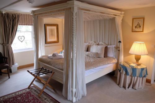 ein Schlafzimmer mit einem Himmelbett mit Baldachin in der Unterkunft The Bedingfeld Arms in Swaffham