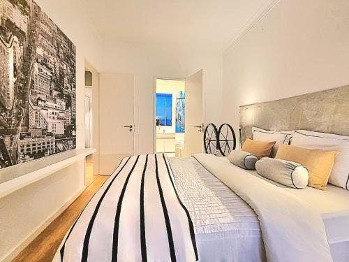 Habitación blanca con cama grande con almohadas en Epic Design: Unforgettable Stay, en Linda-a-Velha