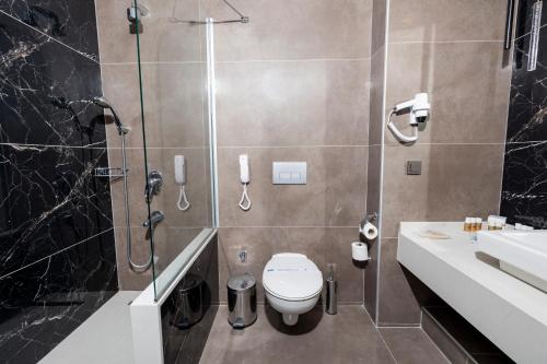 a bathroom with a toilet and a shower and a sink at Crystal Centro Resort - Ultimate All Inclusive in Lara