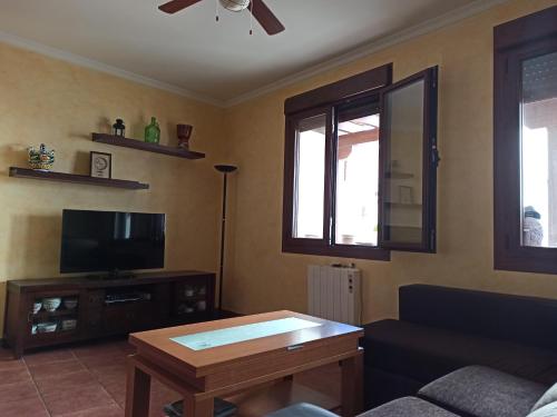 a living room with a couch and a tv at Casa Rural EL ALMEZ in Horcajo de Santiago