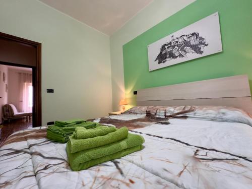 a bedroom with a large bed with green walls at L'OLIVO DI EVELINA in Bagnoregio
