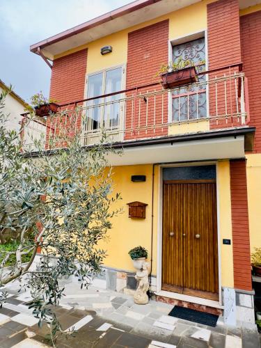 a yellow and red house with a wooden door at L'OLIVO DI EVELINA in Bagnoregio