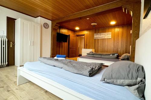 two beds in a room with wooden walls at Work&Stay Apartments Hellenthal in Hellenthal