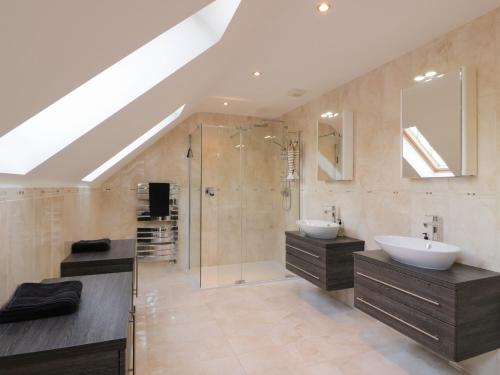 a bathroom with two sinks and a shower at Merse End in Dalbeattie