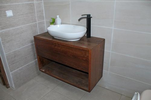 a bathroom with a white bowl sink on a wooden stand at Chambre D'hôtes Morondava in Morondava