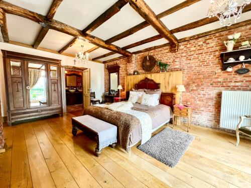 a bedroom with a bed and a brick wall at De Blauwe Maaten in Neerglabbeek