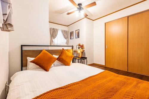 a bedroom with a large bed with orange pillows at アリタビル大国 in Osaka
