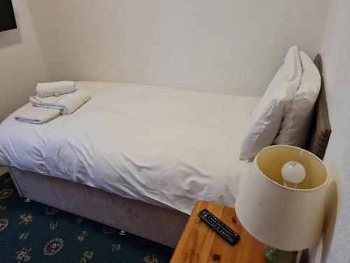 a bedroom with a bed and a table with a lamp at The Sanderling in Morecambe