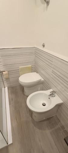 a white bathroom with a toilet and a sink at Casa di Nonna Margherita in Trecase
