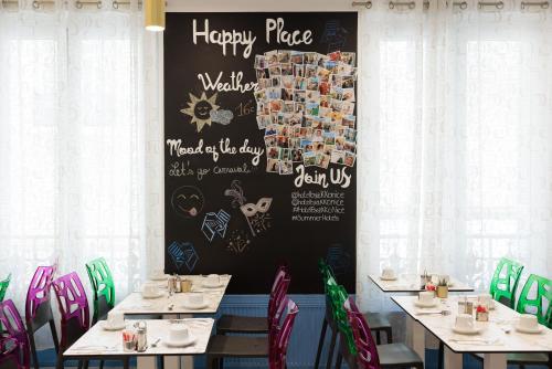 a dining room with tables and chairs and a chalkboard at Hôtel Byakko Nice in Nice
