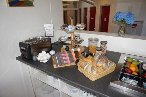 a counter with bread and baskets of food on it at Motel Spar 10 in Viborg