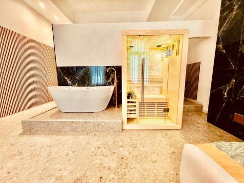 ein Badezimmer mit einer großen Badewanne und einer Dusche in der Unterkunft Palazzo Otello 1847 Wellness & Spa in Vicenza