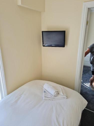 a bedroom with a bed with a tv on the wall at The Sanderling in Morecambe