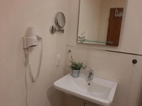 a bathroom with a sink and a mirror and a phone at Fewo Zum Sonnenschein in Simmerath