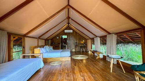 a room with two beds and tables in a house at Glamping Wilpattu by Thamaravila in Wilpattu