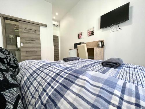 een slaapkamer met een bed met twee handdoeken erop bij Tiny Apartments in Miskolc