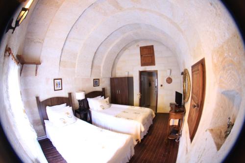 a hotel room with two beds and a window at Urgup Konak Hotel in Urgup