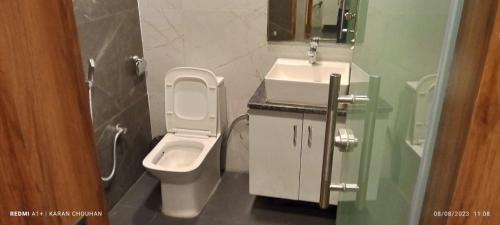 a bathroom with a toilet and a sink at Hotel Vimal Ganga in Rishīkesh