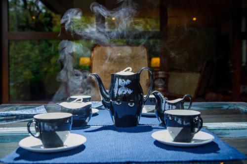 a table with three tea cups and a tea pot at Hailsham Bungalow in Sri Jayewardenepura Kotte