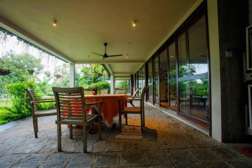 a dining room with a table and chairs on a patio at Hailsham Bungalow in Sri Jayewardenepura Kotte