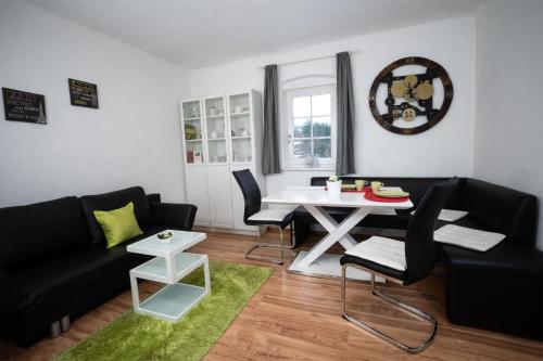 uma sala de estar com um sofá preto e uma mesa branca em Bahnwärterhaus em Pregarten