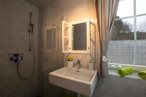 uma casa de banho com um lavatório e um chuveiro com uma janela em Bahnwärterhaus em Pregarten